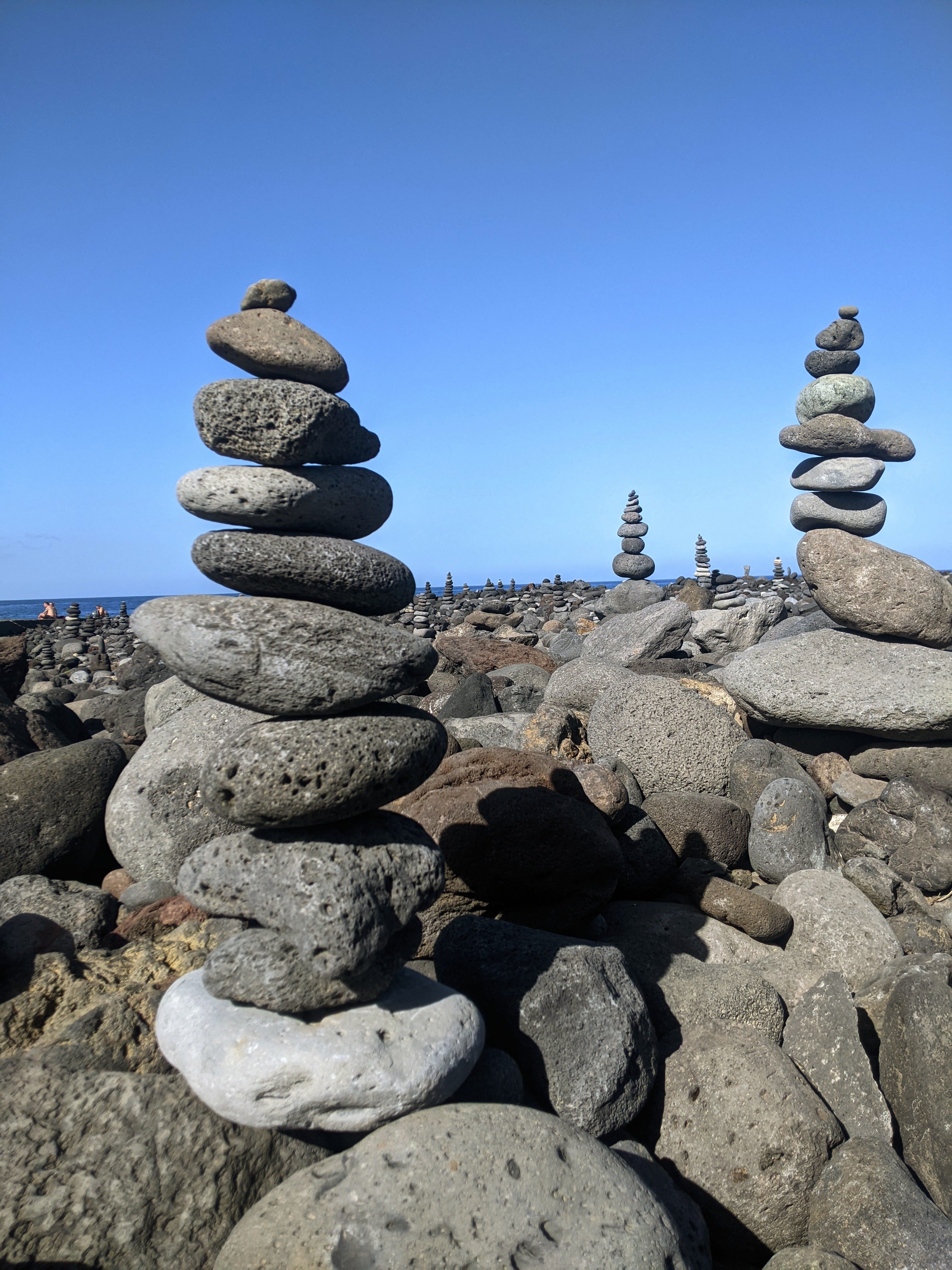 Aufeinandergestapelte Steine am Meer