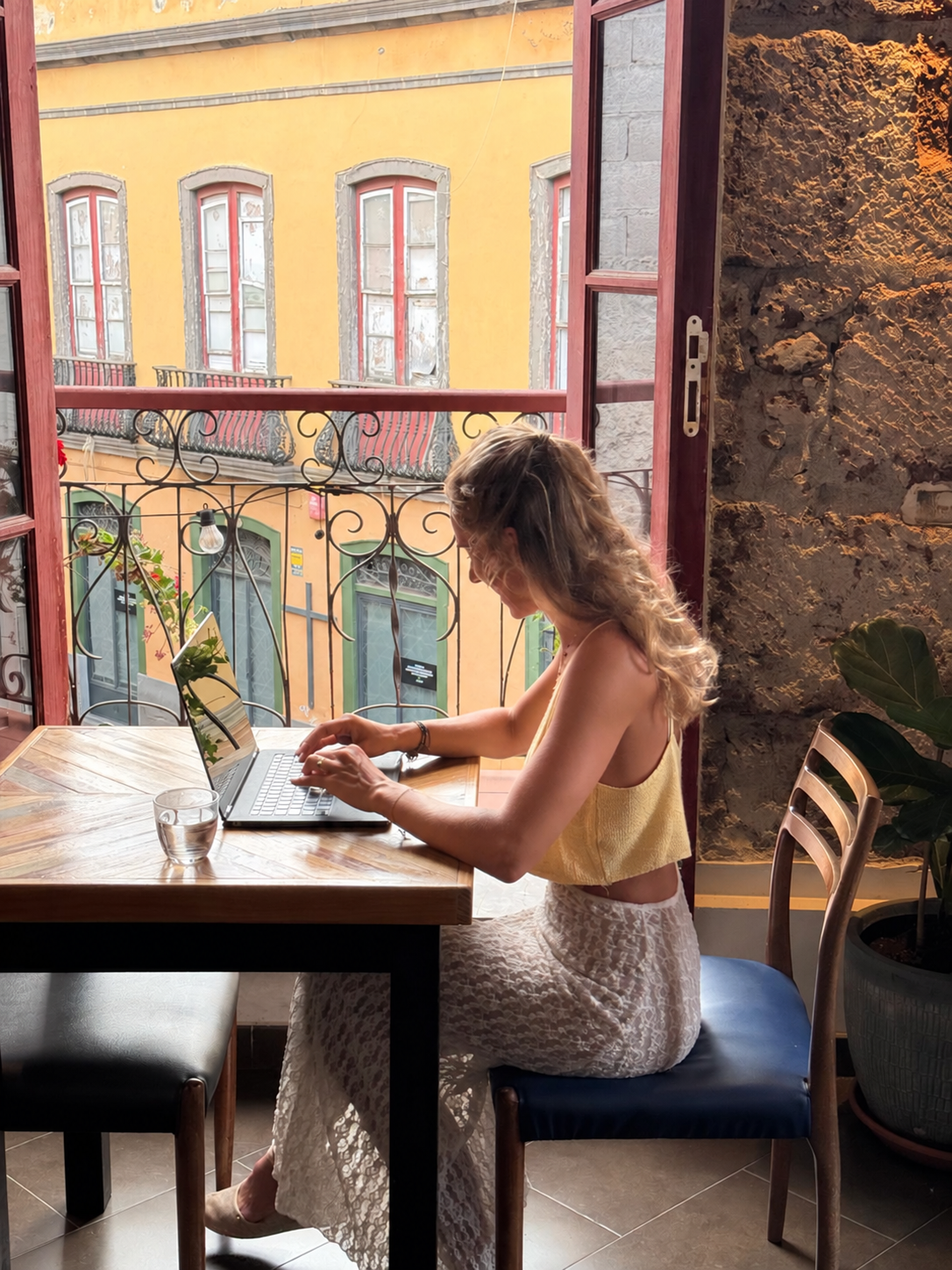 Theresa Pohl arbeitet am Laptop am offenen Fenster